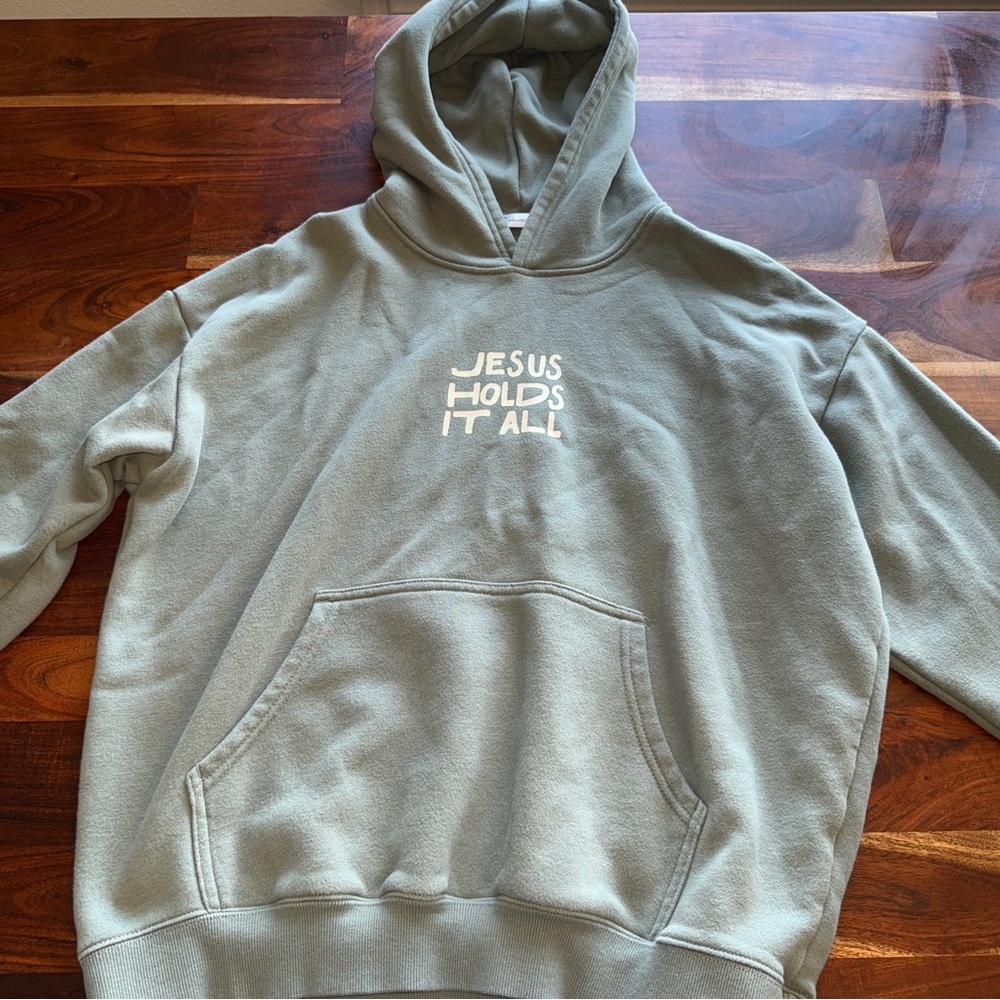 Elevated Faith Jesus Holds It All Hooded Sweatshirt - Sage Green